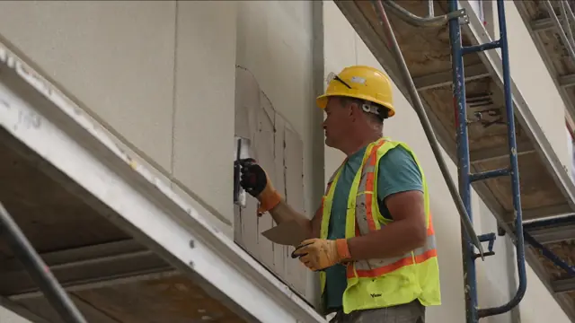 Crew member installing EIFS on scaffold